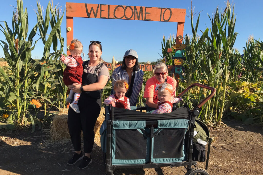 Therapists and little kids pictured at the entrance to a pumpkin patch